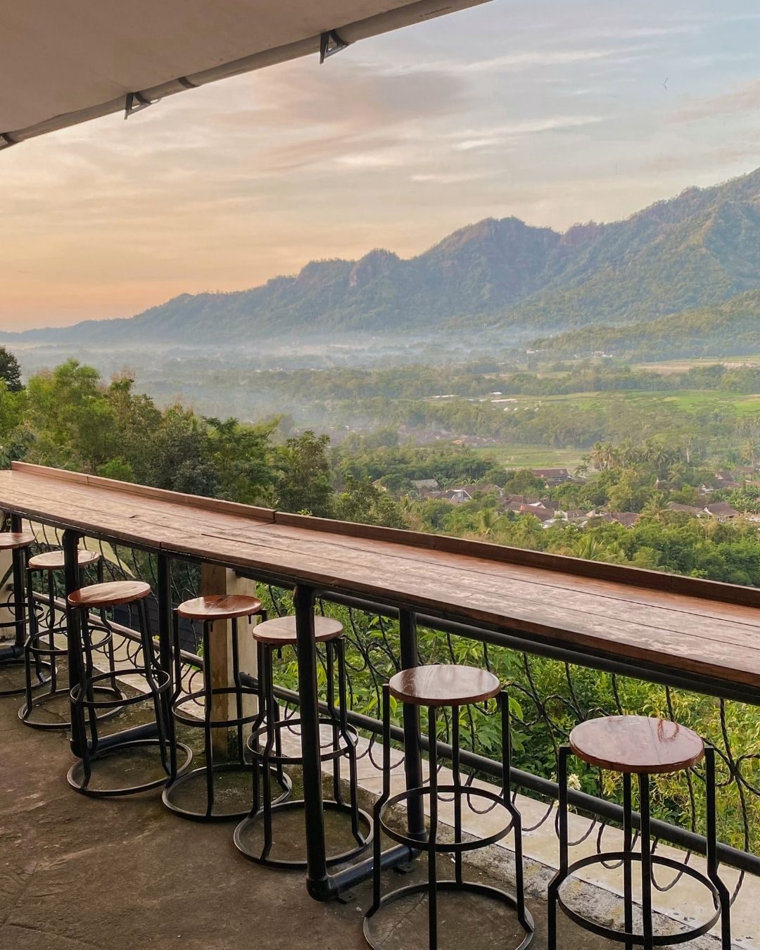 Bar seating facing the Menoreh Hills in soft light at Kedai Bukit Rhema
